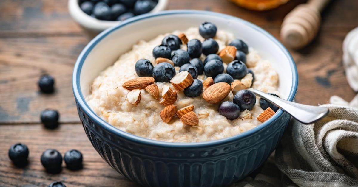 Oatmeal Porridge with Nuts and Blueberries in a Blue Bowl
