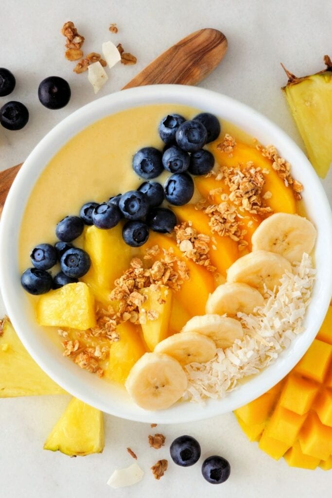 Tropical Breakfast Smoothie Bowl with Blueberries, Mangoes, Bananas, Coconut, and Oats