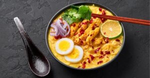 Burmese Chicken Curry Soup in a Bowl with Eggs and Lime