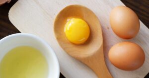 Egg Yolk and Egg White Separated in a Wooden Table