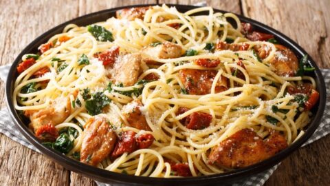 Homemade Chicken Pasta with Sun-Dried Tomatoes in a Black Plate