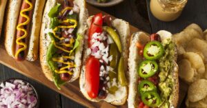 Homemade Gourmet Hot Dogs with Chips in a Wooden Board