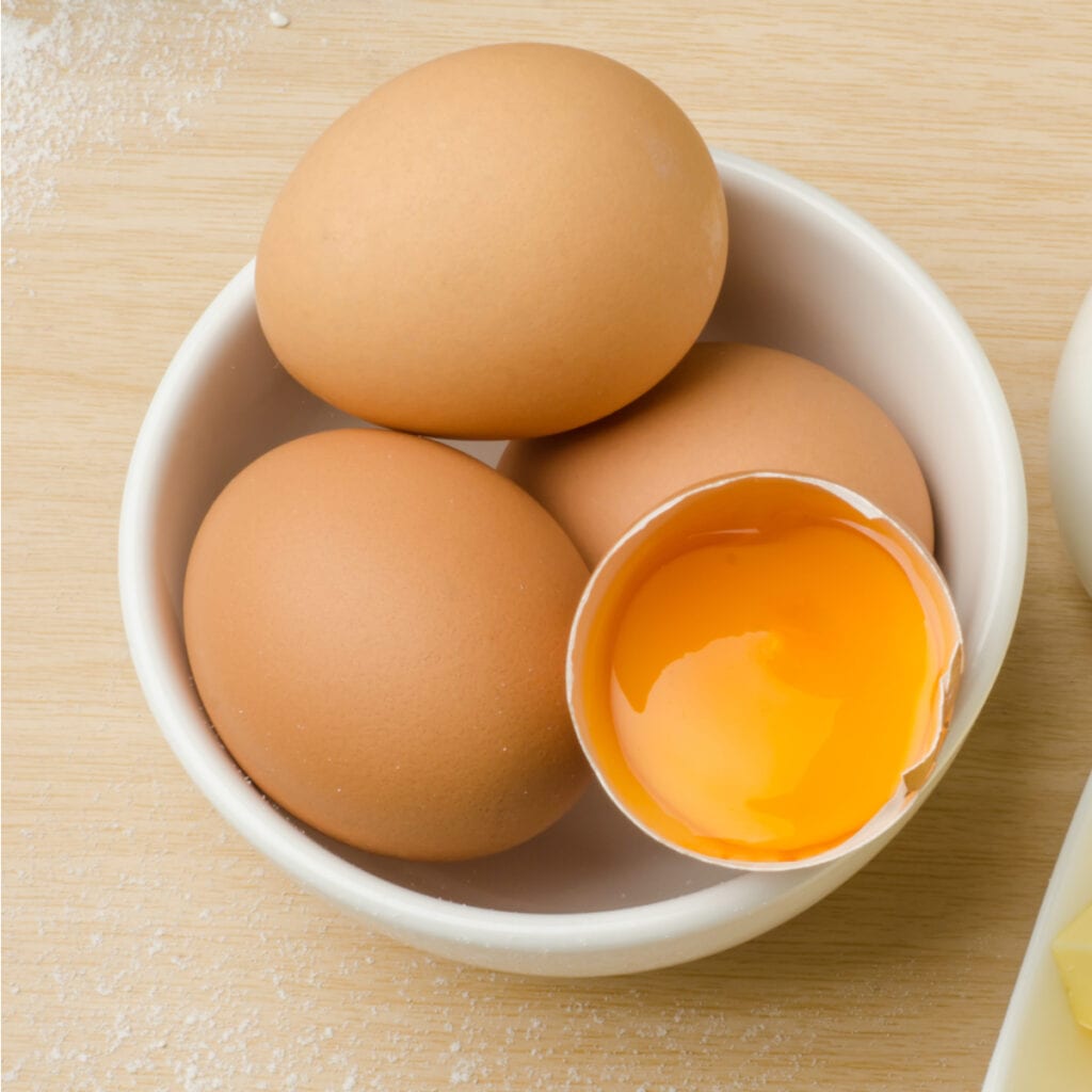 Raw Eggs with Egg Yolk in a White Bowl