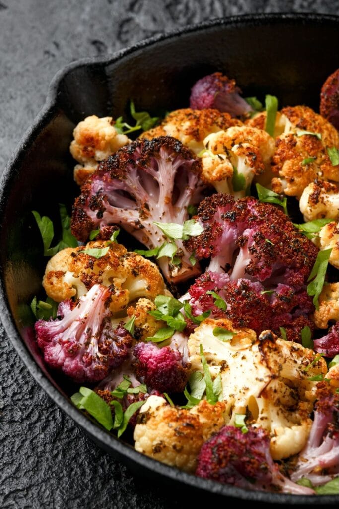 Roasted White and Purple Cauliflower in a Black Bowl