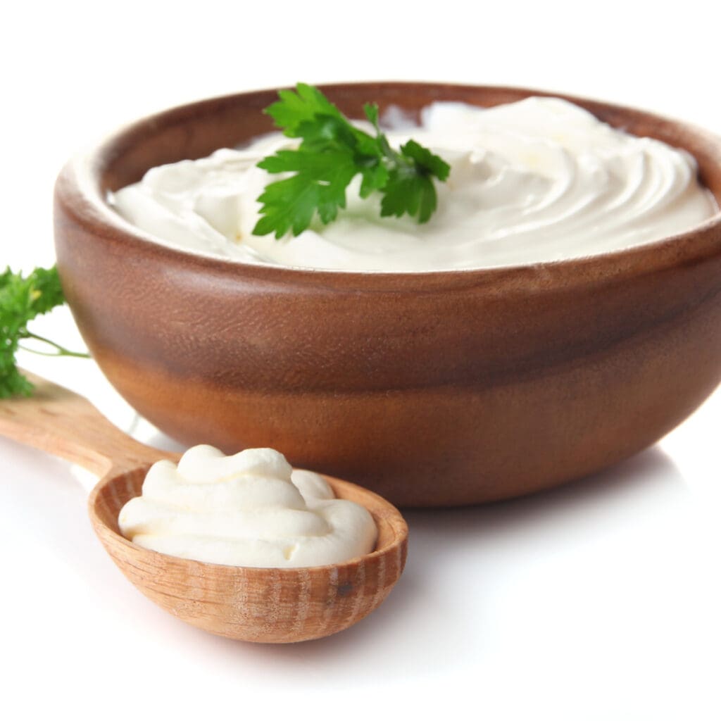 Sour Cream in a Wooden Spoon and Bowl