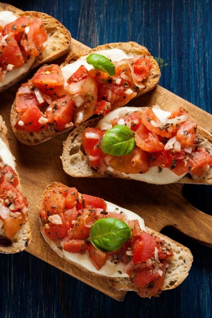 Tomato Bruschetta with Cheese on a Wooden Board