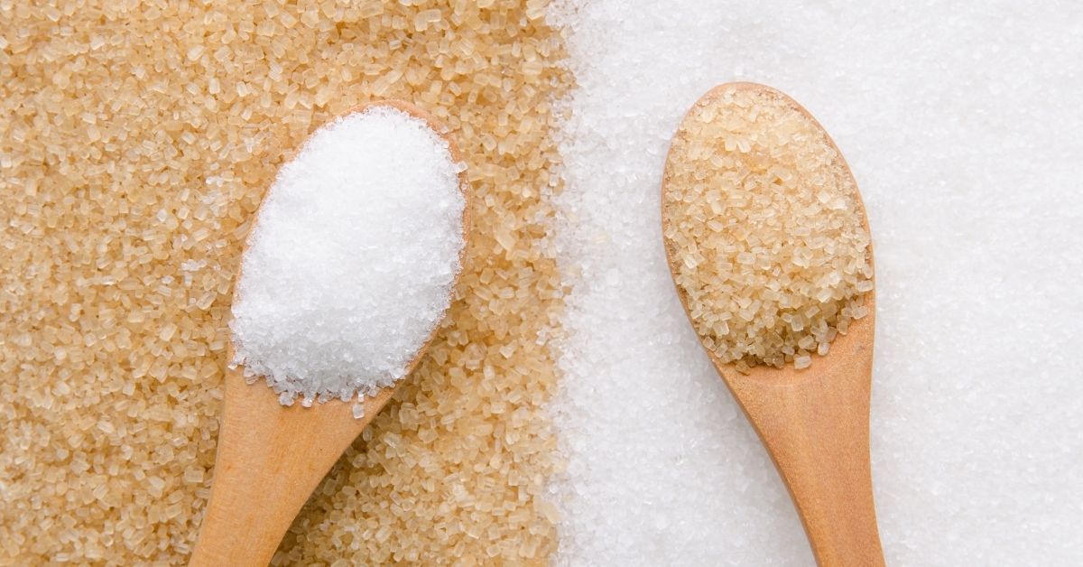 White and Brown Granulated Sugar in a Wooden Spoon