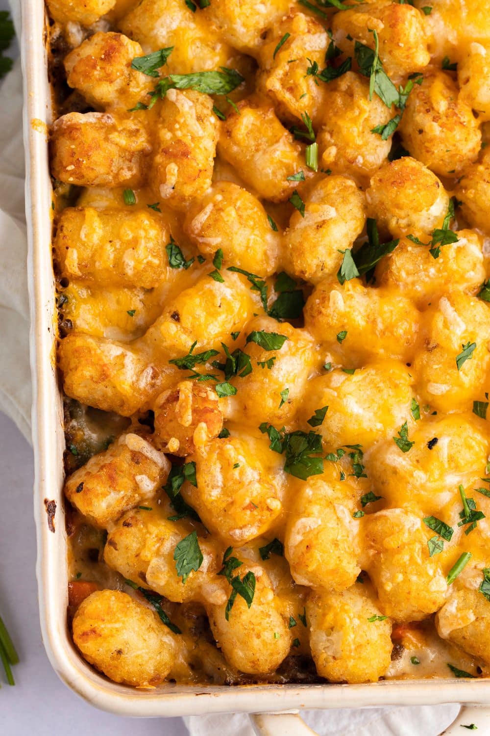 Tater Tot Casserole with Ground Beef in a white baking dish