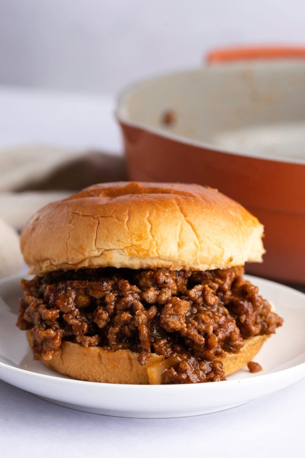 Sloppy Joes made with buns and ground beef filling served on a white plate. 