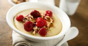 Bowl of Homemade Semolina Pudding with Raspberries and Nuts
