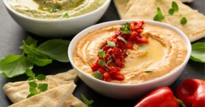 Bowl of Hummus with Roasted Red Peppers and Pita Chips