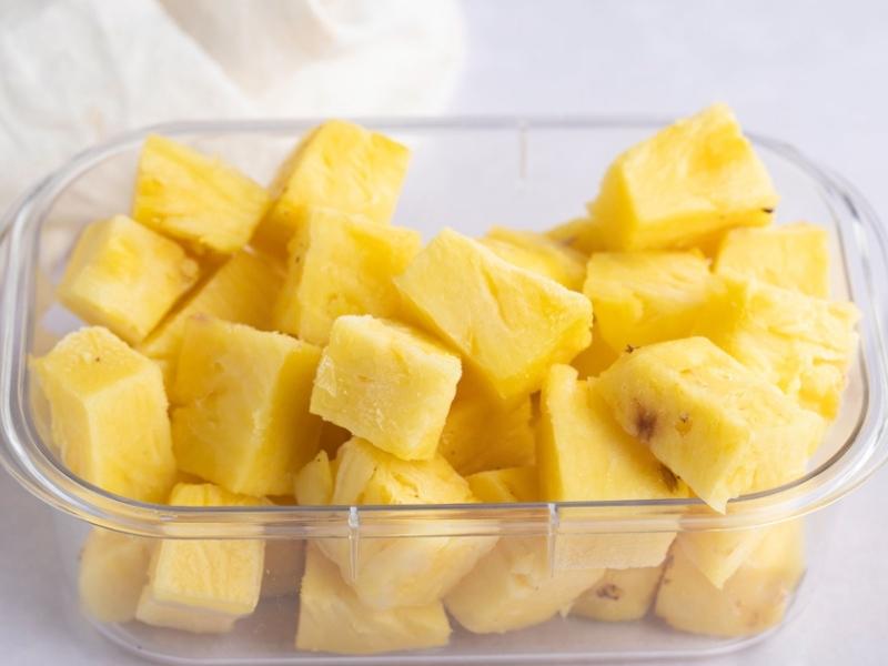 How to Freeze Pineapple: frozen pineapple slices on a clear square container