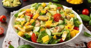Homemade Chicken Mango Salad with Cucumber and Tomatoes in a White Plate