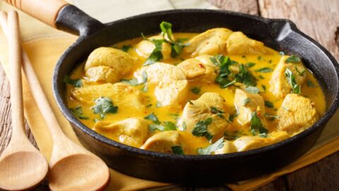 Homemade Spicy Chicken Coconut Curry with Herbs in a Skillet