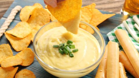 Nacho Cheese Dip with Green Onions in a Glass Bowl