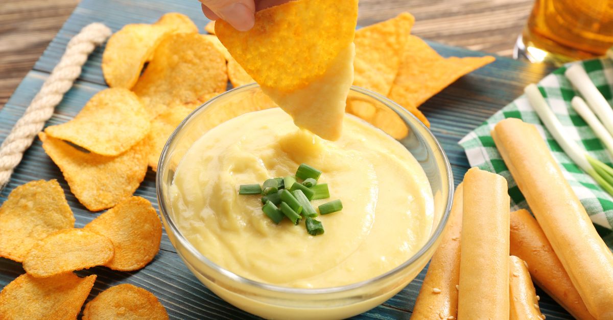 Nacho Cheese Dip with Green Onions in a Glass Bowl