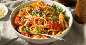 Bowl of Homemade Bucatini Pasta with Tomato and Basil