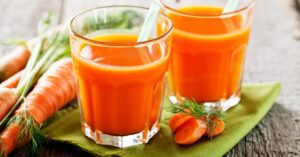 Carrot Juice in a Glass with Fresh Carrots