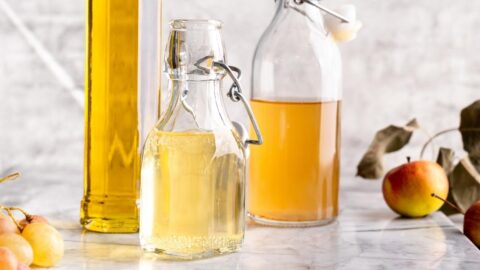 Glass Bottles of White Wine Vinegar in a Marble Table