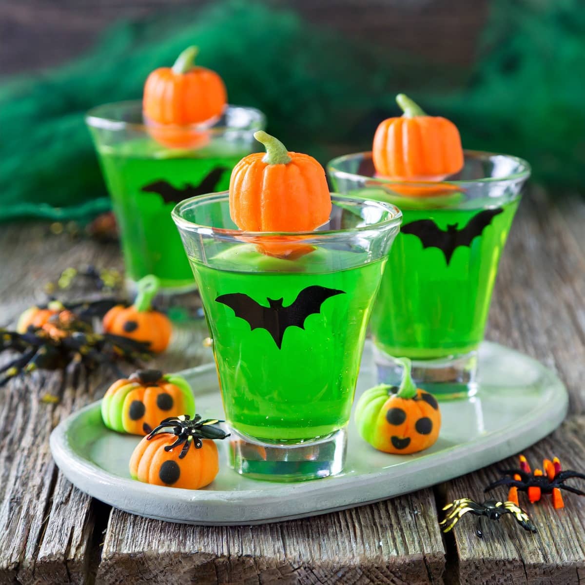 Green Jello shots for Halloween with mini pumpkins