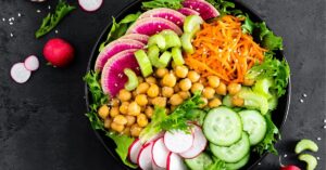 Homemade Healthy Buddha Bowl salad with Celery, Chickpeas, Cucumber, Carrots and Watermelon Radish