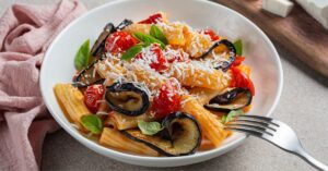 Homemade Penne Pasta with Eggplant, Tomatoes and Ricotta Cheese in a White Bowl
