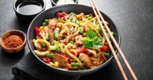 Homemade Stir-Fry Udon Noodles with Chicken and Vegetables in a Bowl
