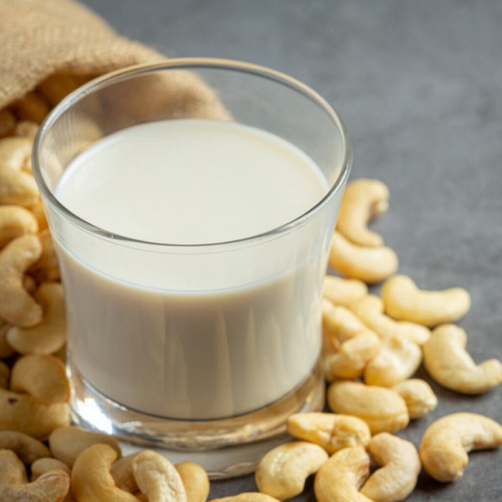Almond Milk in a Glass and Fresh Almond Nuts