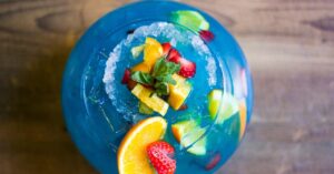 Boozy Fish Bowl Cocktail with Blue Curacao and Fresh Fruits