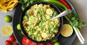Bowl of Guacamole with Avocados, Lime and Red Tomatoes