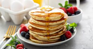 Classic Pancake with Butter and Berries Poured with Syrup