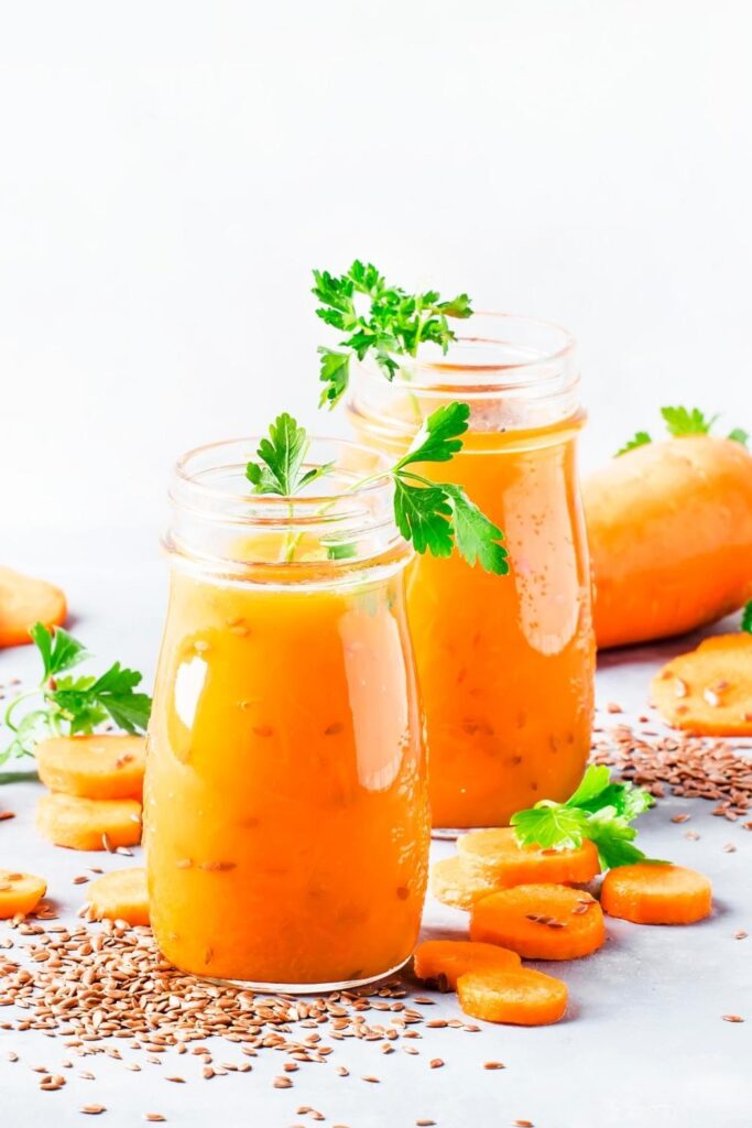 Fresh and Healthy Carrot Smoothie in a glass bottle with fresh herbs