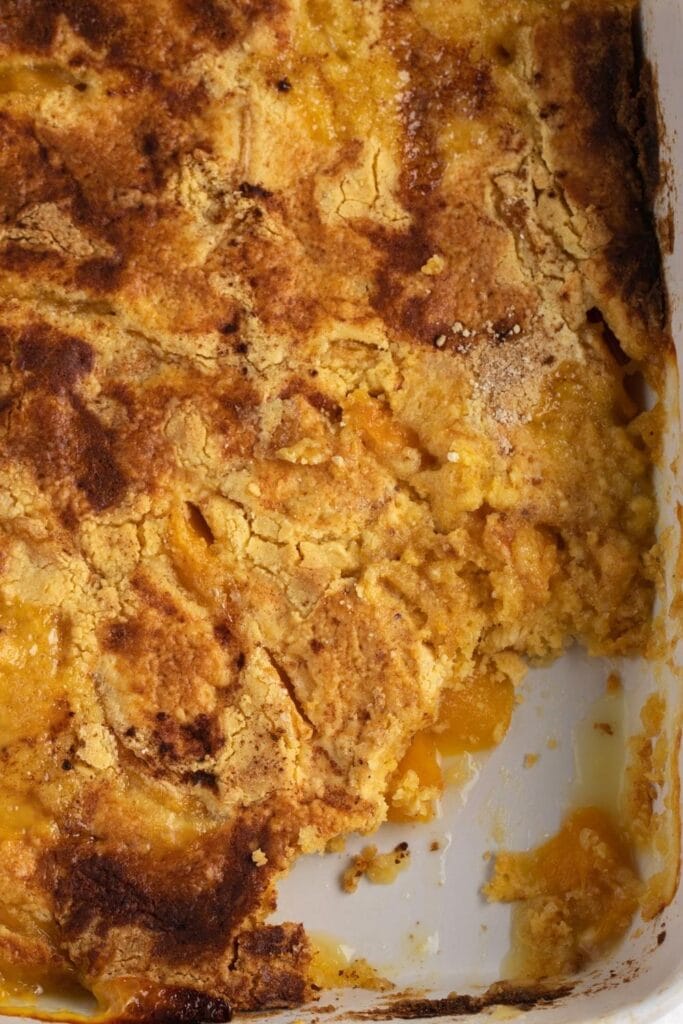 Crumbly Peach Dump Cake on a White Baking Pan