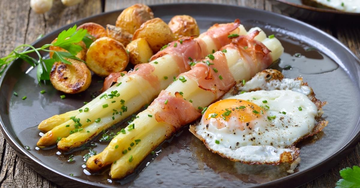Homemade Baked White Asparagus Wrapped in Bacon with Potatoes and Egg