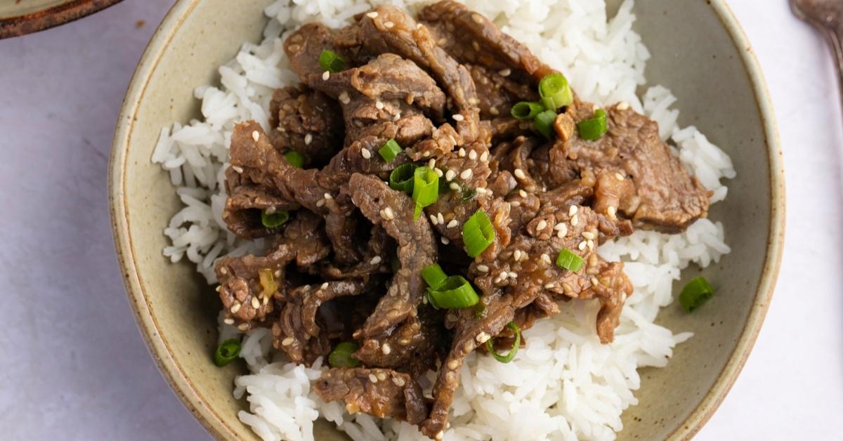 Homemade Beef Bulgogi and Rice with Green Onions and Sesame Seeds in a Bowl