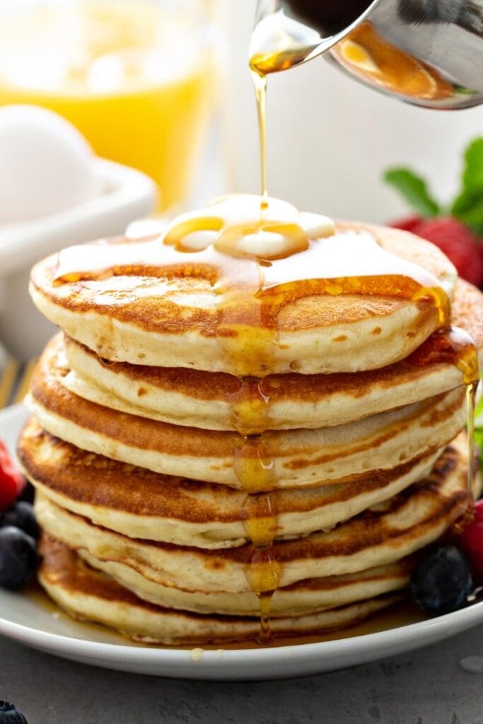 Stack of Homemade Classic Pancake with Butter, Berries and Maple Syrup