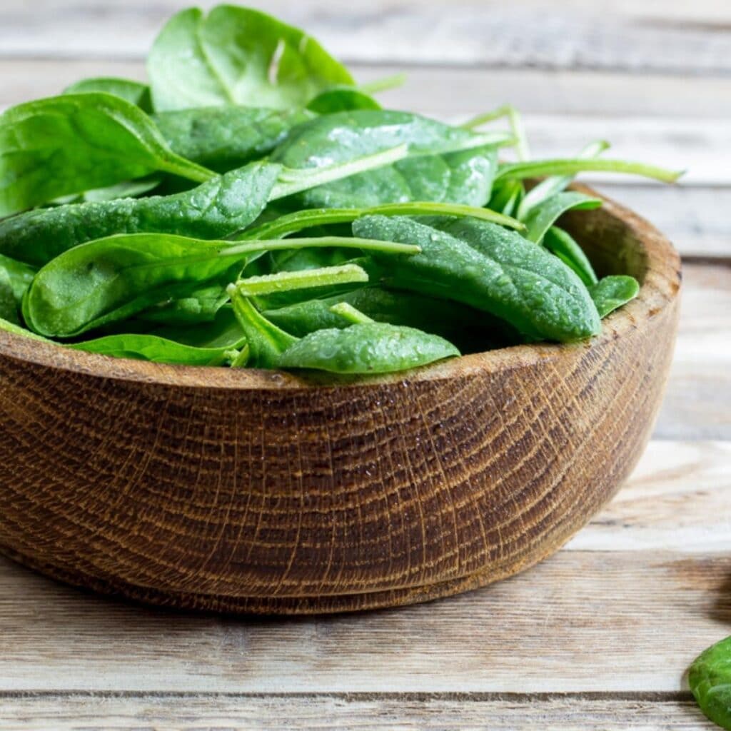 Spinach Leaves on a Wooden Bowl