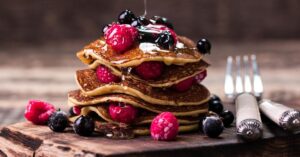 Tasty Homemade Buckwheat Flour Pancakes with Berries and Syrup