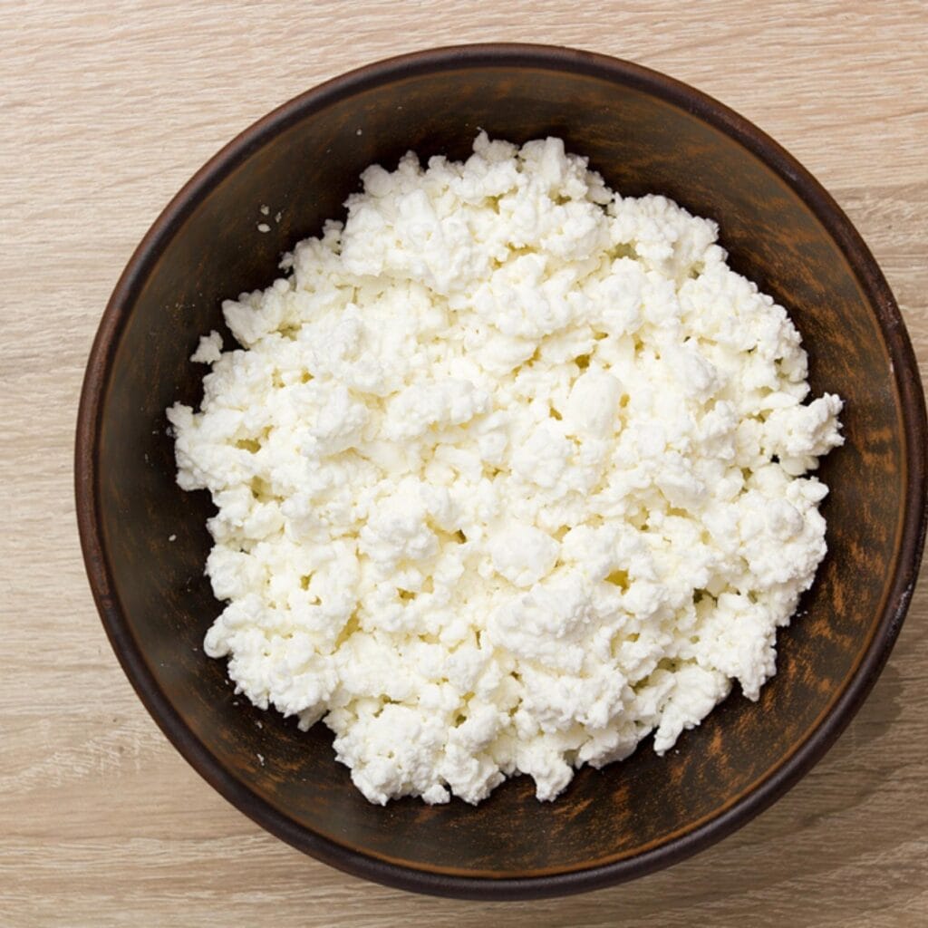 Grated White Cheese on a Wooden Bowl