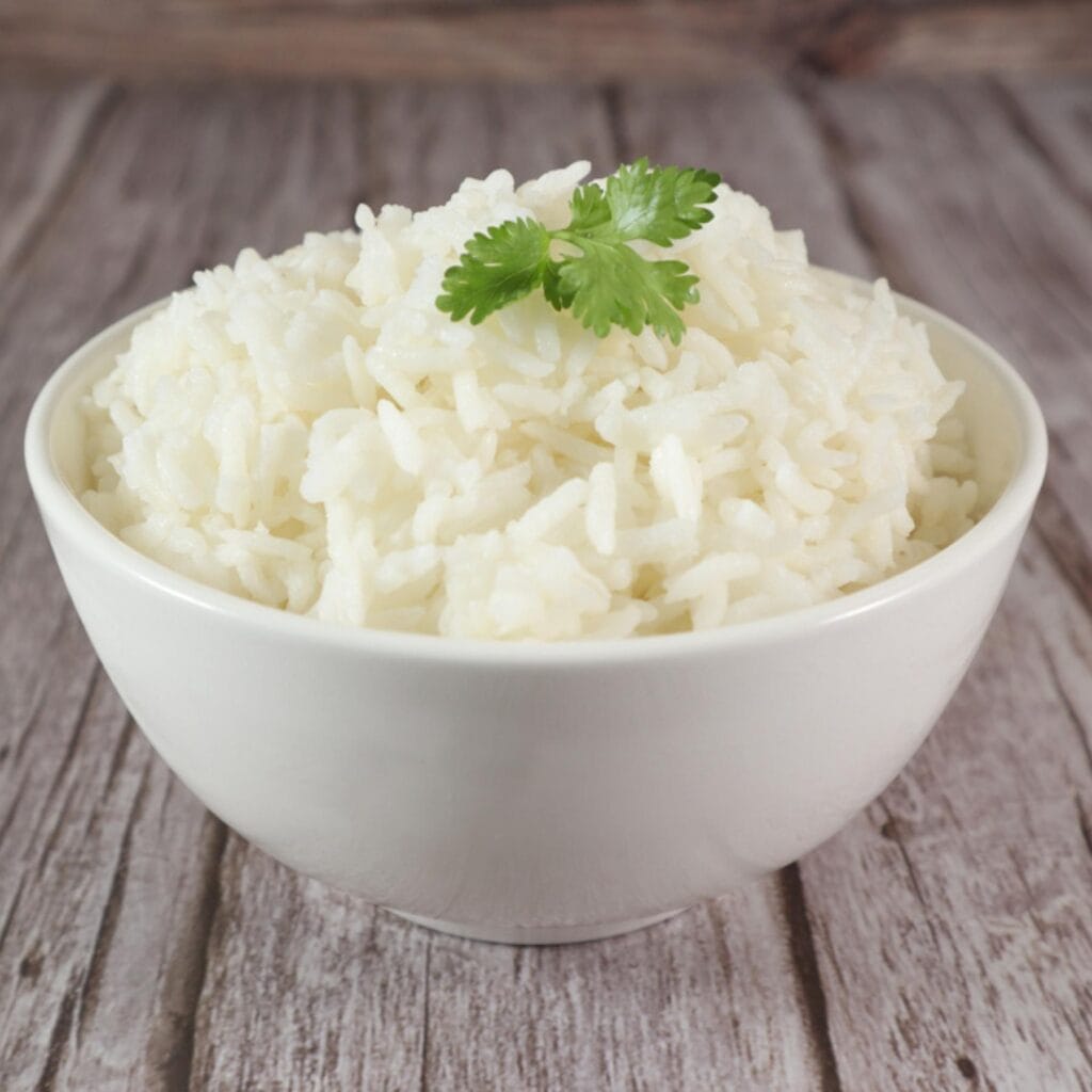 A bowl of white rice with parsley on top