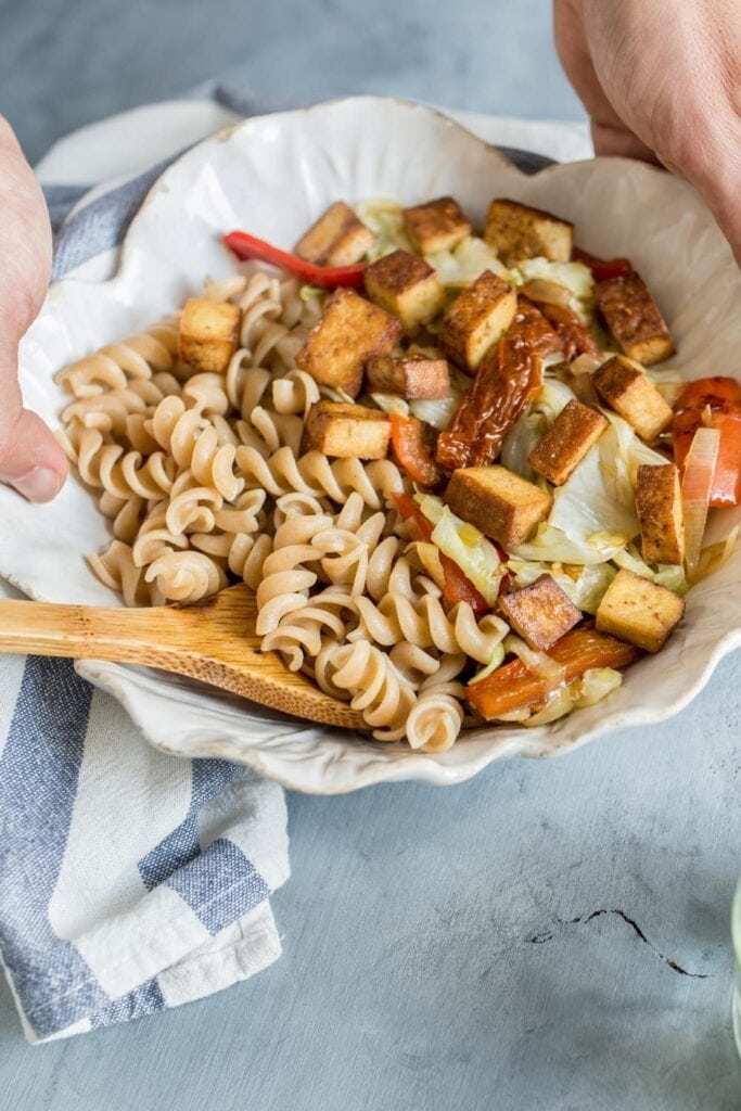 Woman Holding Pasta Salad with Tofu and Pepper