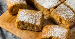 Apple Sauce Cake with Powdered Sugar in a Wooden Cutting Board