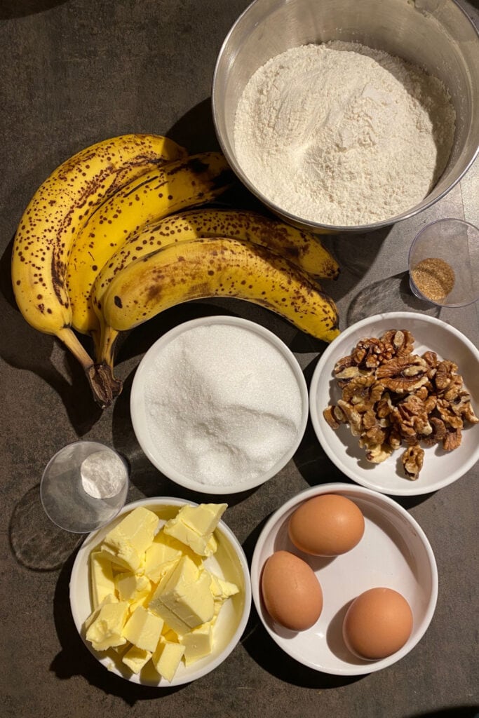 Banana Bread Ingredients: Nuts, Flour, Sugar, Baking Powder, Salt, Cinnamon, Eggs, Butter, Bananas, and Vanilla