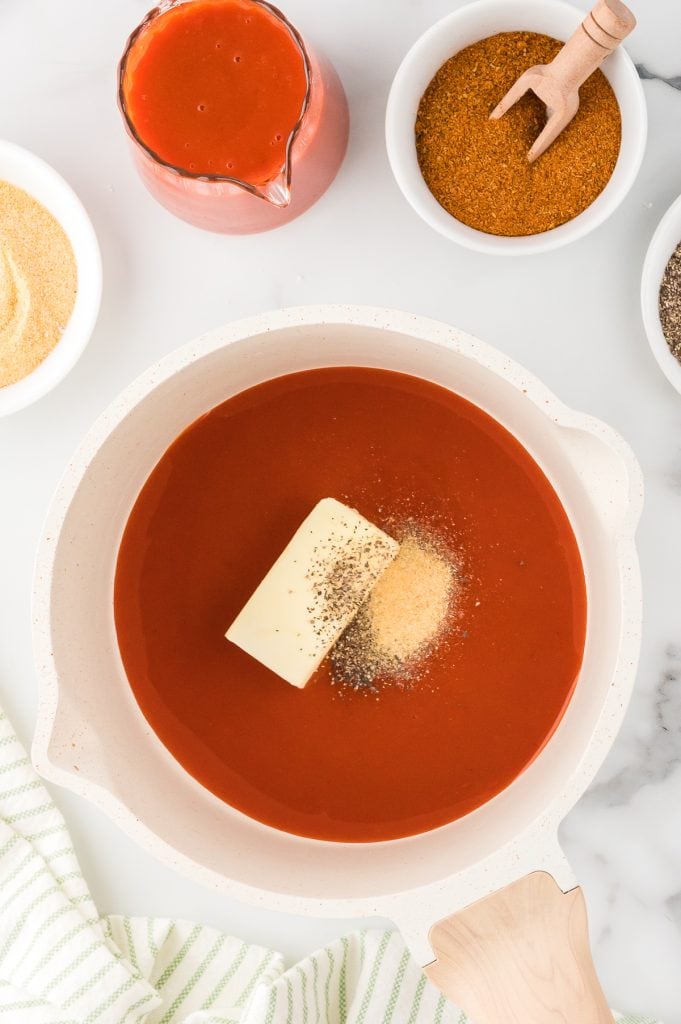A saucepan with buffalo sauce, butter, and spices, top view