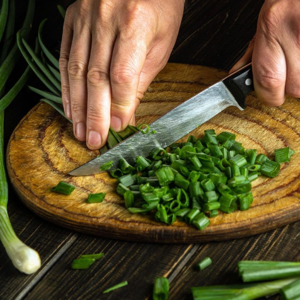 Chopped Green Onions in a Wooden Cutting Board