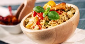 Couscous Salad with Meat and Vegetables in a Wooden Bowl