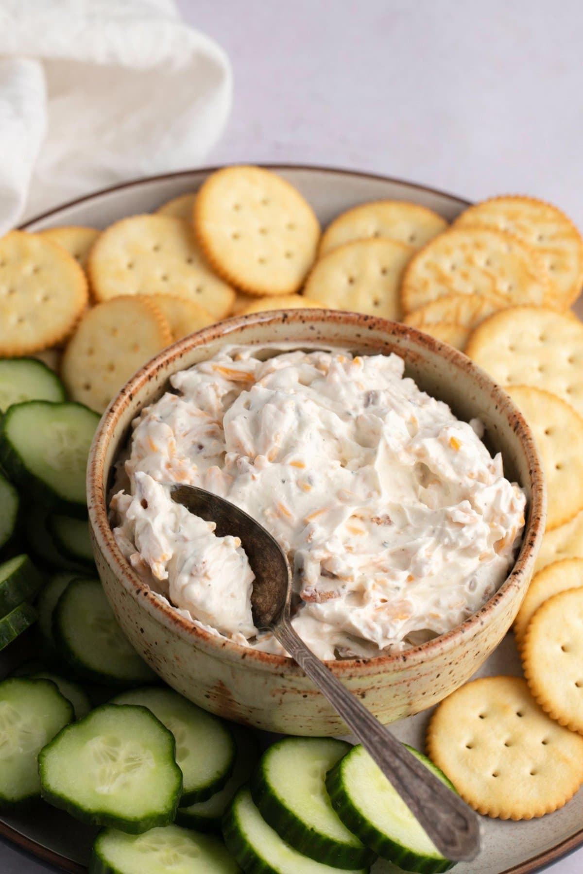 Creamy Hidden Valley Ranch Dip with Bacon & Cheddar on a platter with crackers and cucumbers
