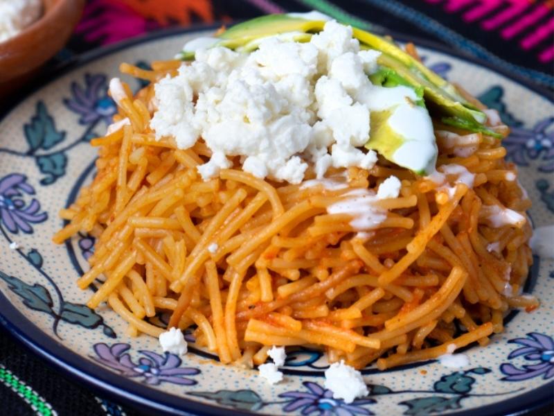 Fideo Noodles Dish Topped With Crumbled Cottage Cheese and Avocado Slice