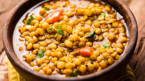 Homemade Split Pea Soup with Tomatoes in a Wooden Bowl