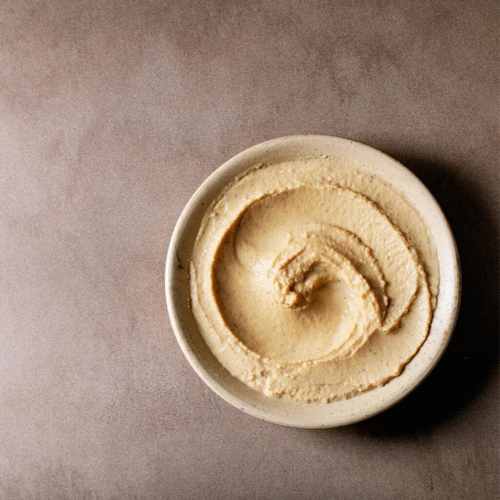 Hummus su un piccolo piatto marrone